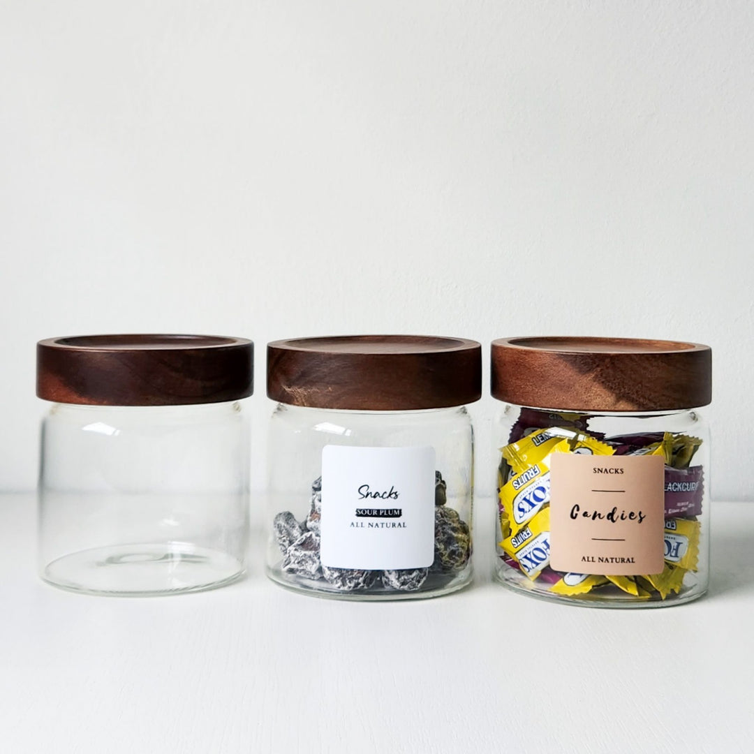 Three glass jars with wooden lids on a white background
