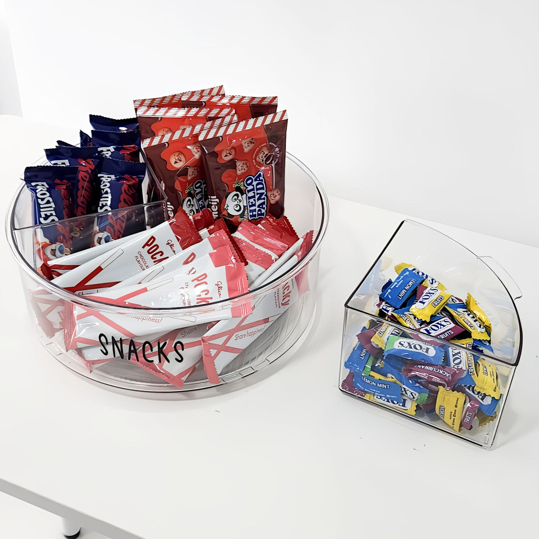 Clear acrylic snack and candy containers with various snacks on a white background