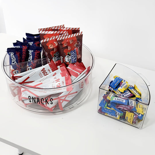 Clear acrylic snack and candy containers with various snacks on a white background
